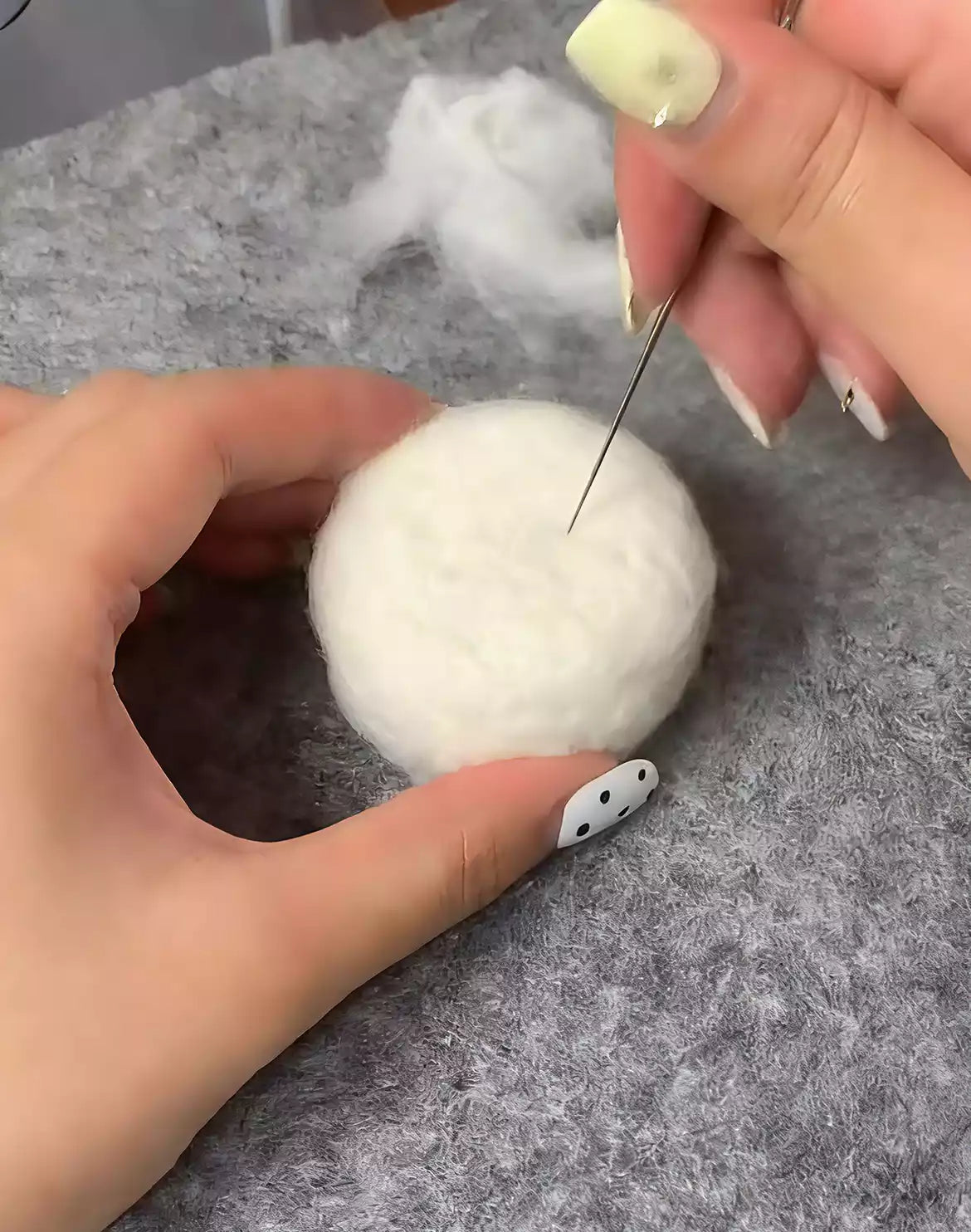 Handmade needle felt work: compressing wool fibers to form the base for a pet figure
