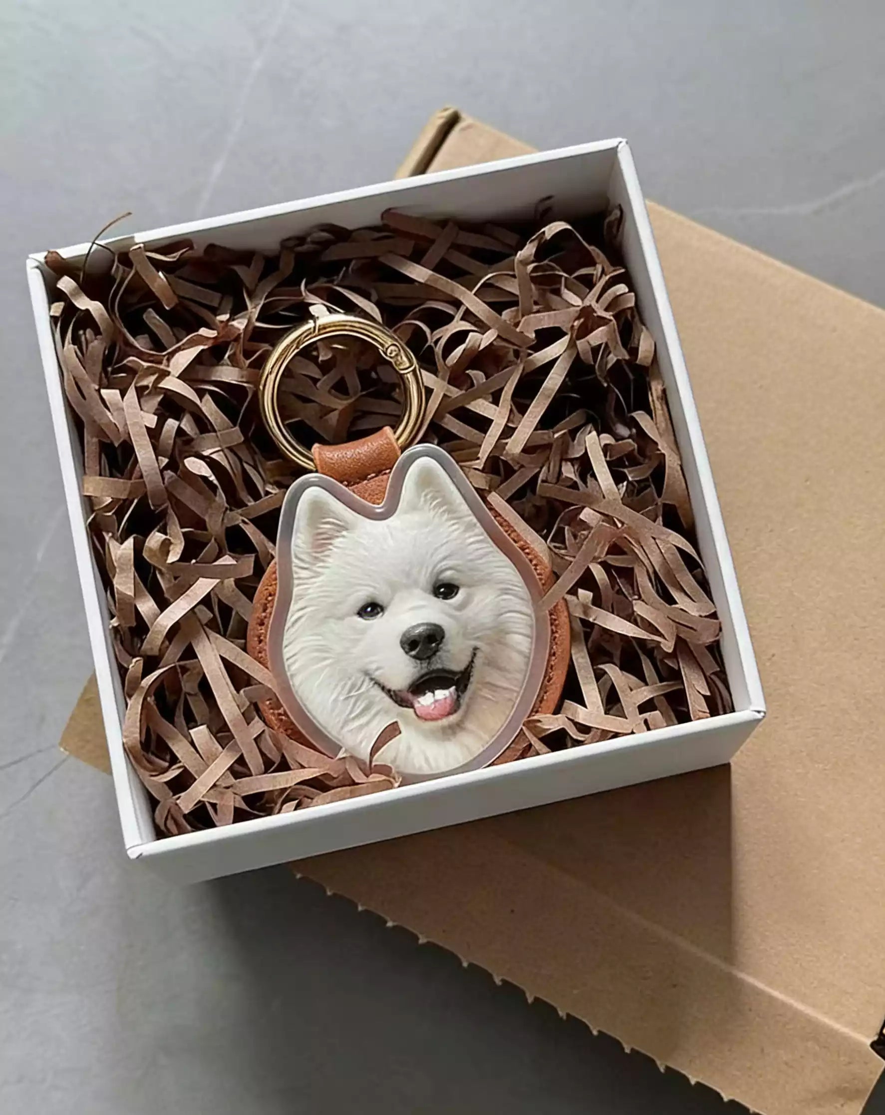 Custom acrylic pet photo keychain featuring a white dog, displayed in a gift box with shredded paper filler