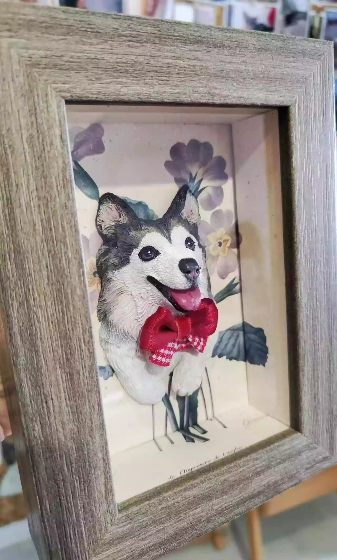 Custom 3D pet portrait shadow box featuring a dog with a red bow, displayed in a tabletop frame