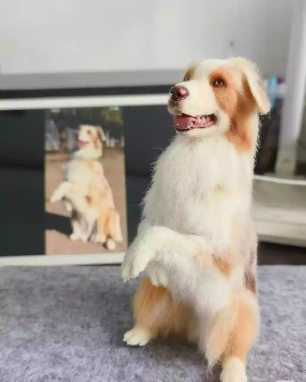 Custom needle-felted dog figurine sitting on a table, modeled after a small white-and-tan dog.